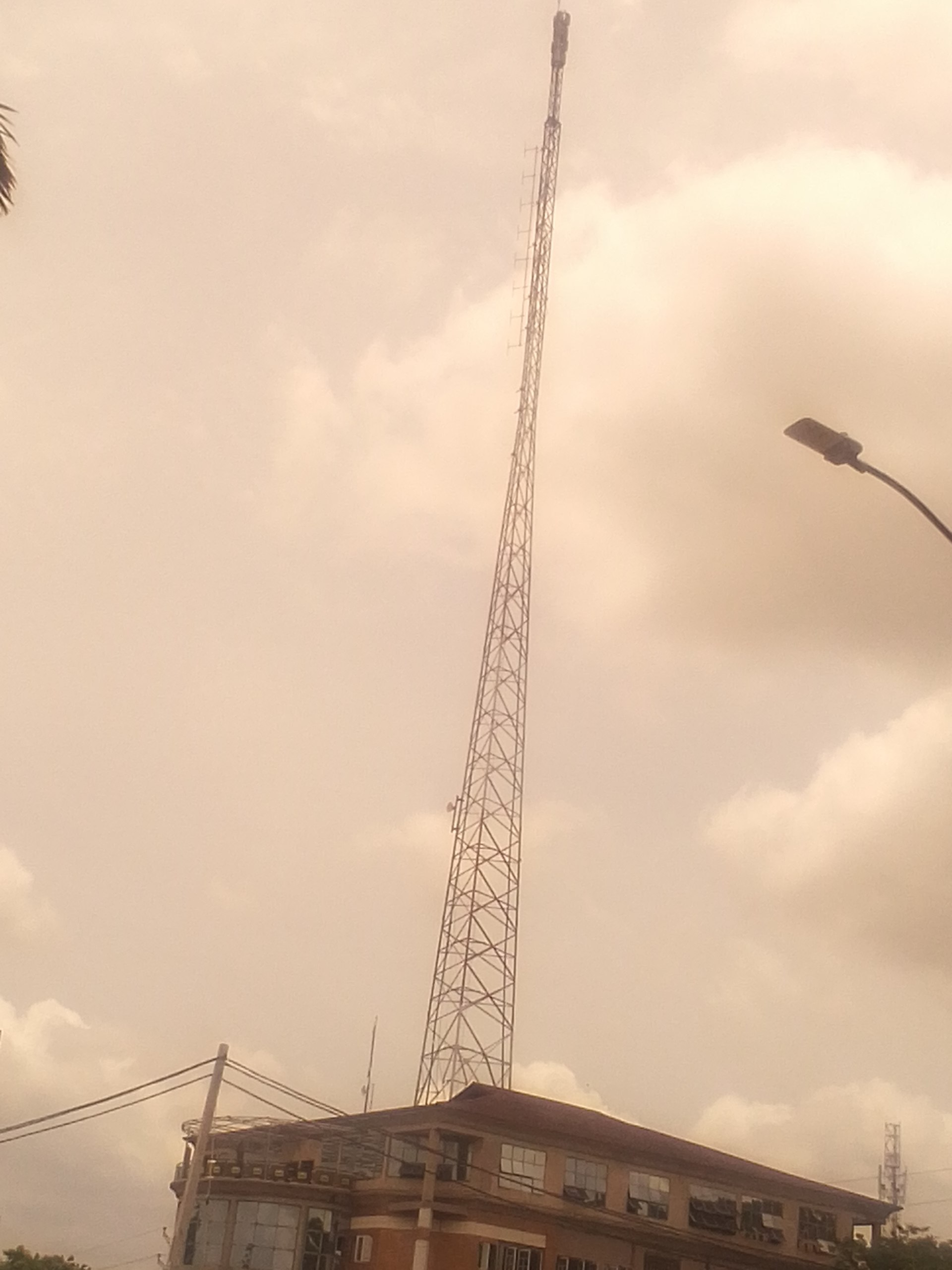 A telecommunications mast rising over an office building in Nigeria